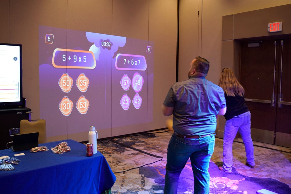 People playing a projector game at Tech Tour